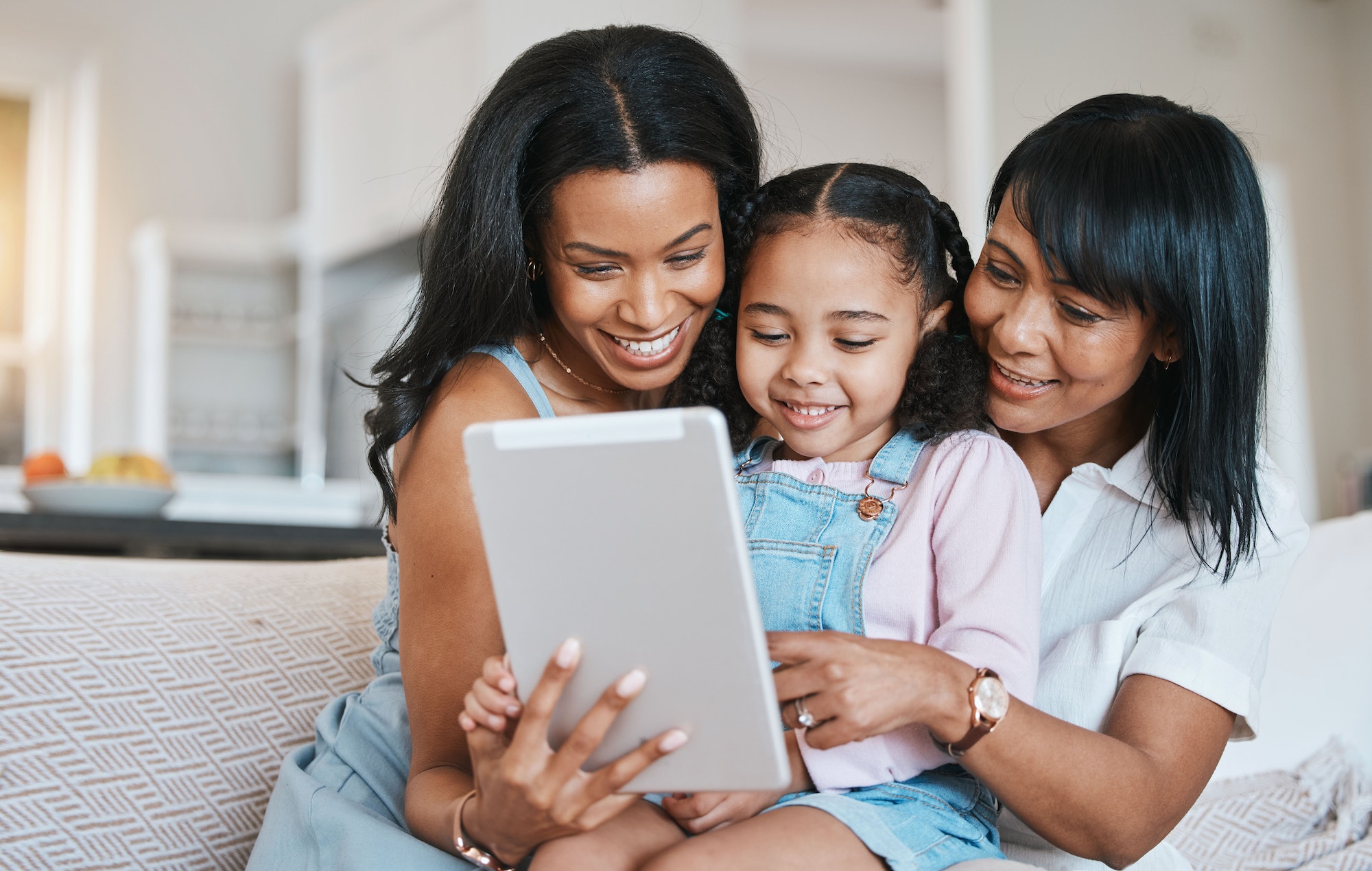 Family, tablet and child on a children education app with mother and grandparent at home. Happiness