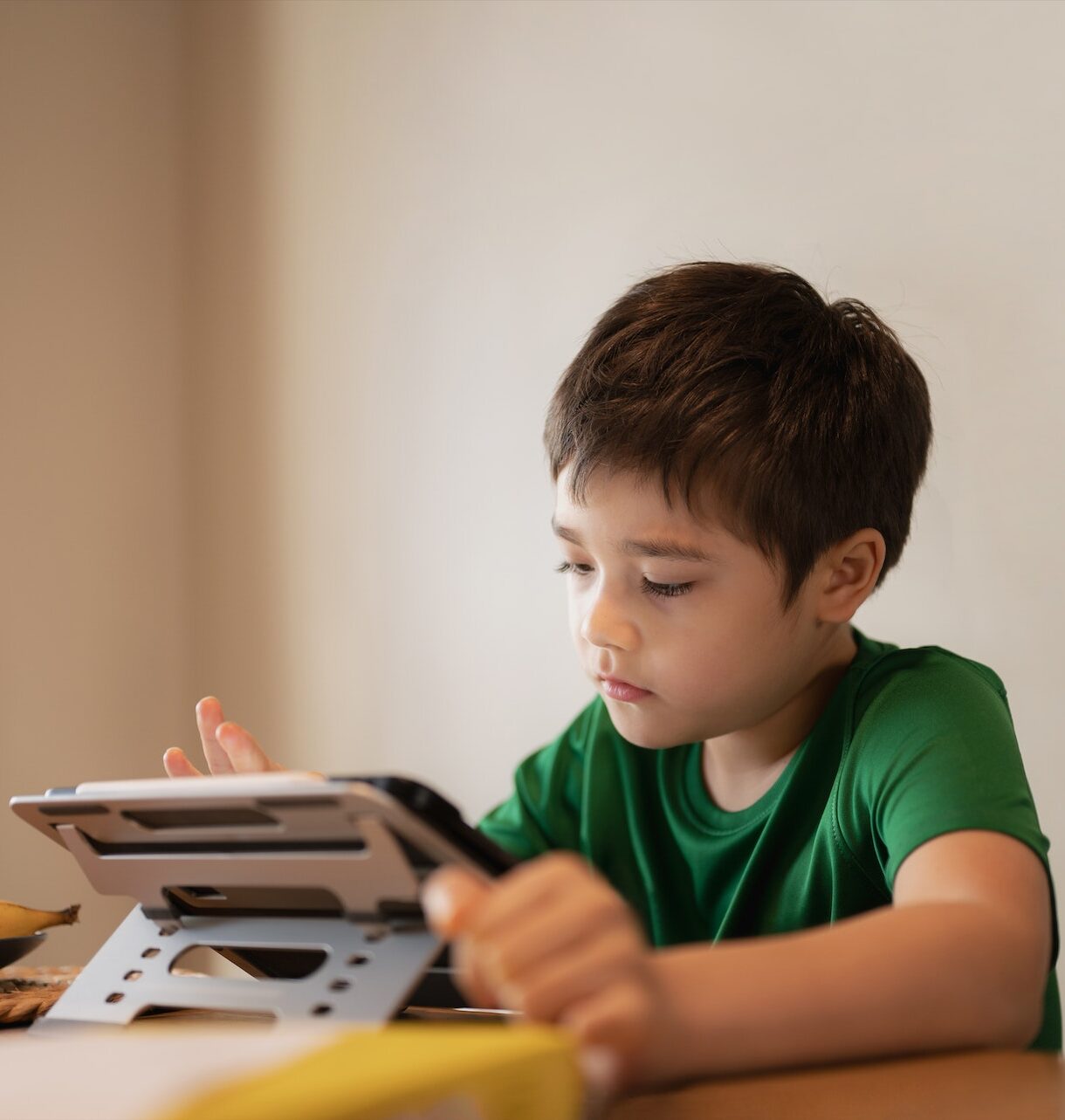 Kid playing game online with friends on tablet