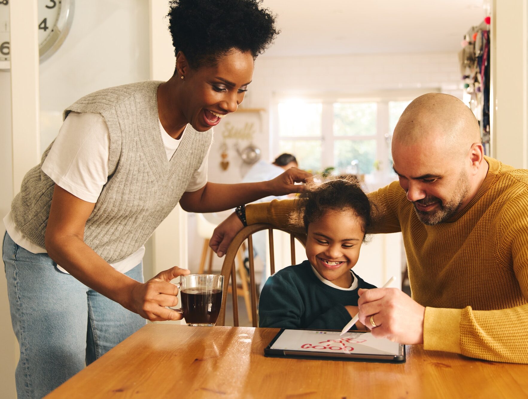 Parents and son with Down syndrome drawing on digital tablet